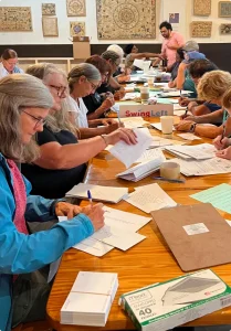 Volunteers at a table preparing letters to mail to voters.